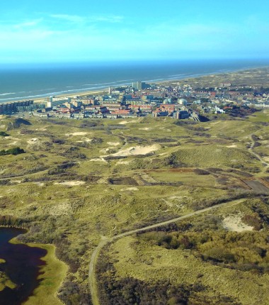 Dronefoto duinen en dorp.JPG
